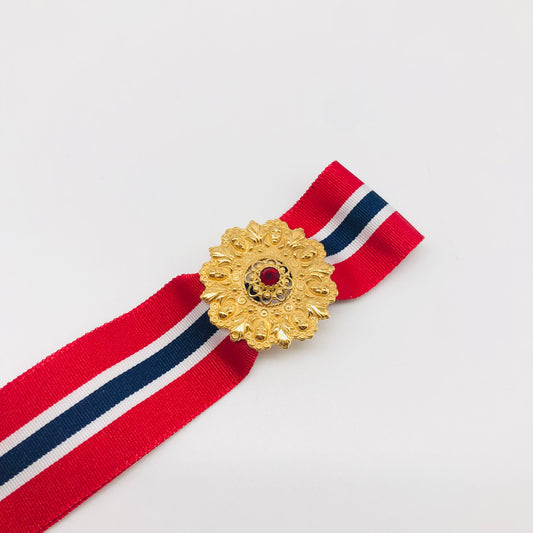 Syvsmidja's new May 17th corn loop and buckle. The bow band can be removed, and you can wear just the strap. Just as nice for everyday as for a party. Sylvsmidja May 17th Bow Pin 2 in 1 with red stone, gold plated