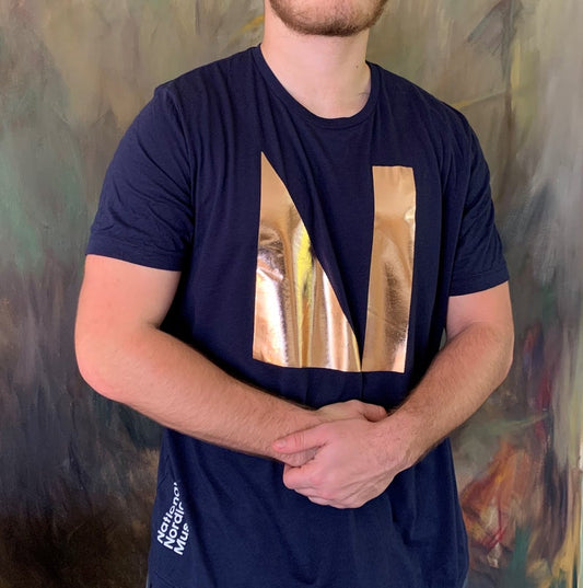 Show your pride in the National Nordic Museum by sporting this cute tee! Our newest poly cotton t-shirt comes in navy blue with a shimmery rose gold foil logo.