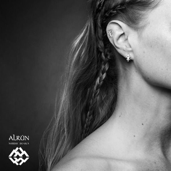 Small but mighty! These charming silver studs reflect the warmth and courage of our classic Heart bindrune. Earrings are rhodium coated .925 sterling silver. 11mm in length. Alrun Stud Earrings